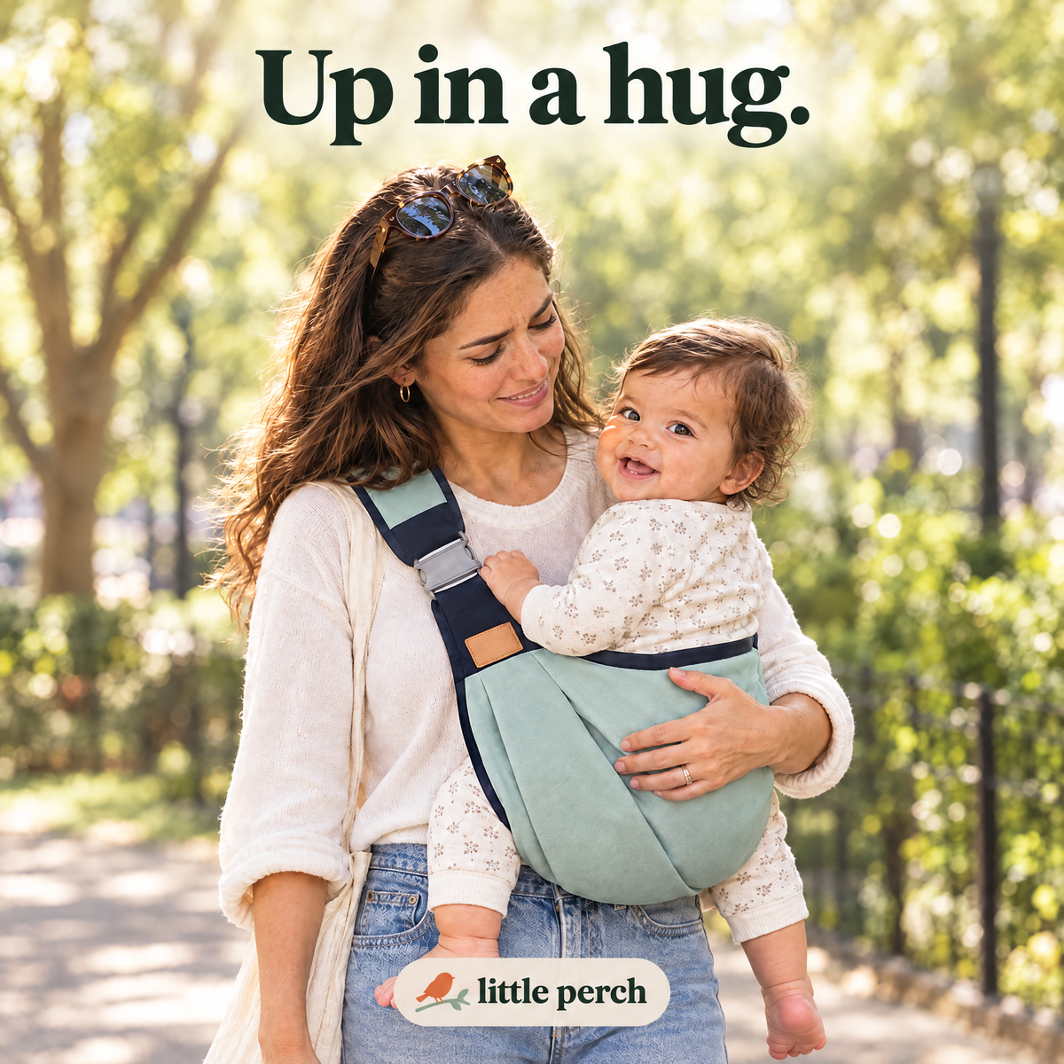 Mother carrying her smiling toddler on her hip in the Little Perch carrier